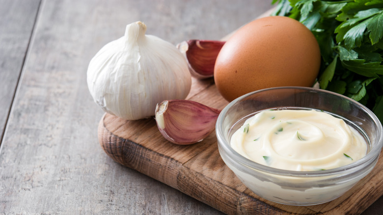 Glass bowl of aioli on cutting board