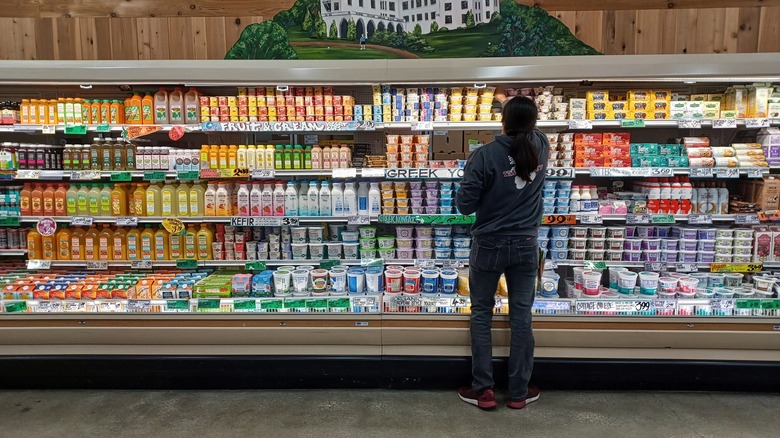 A customer taking at item from the refrigerated shelves at Trader Joe's