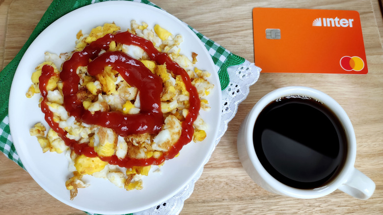A plate of scrambled eggs with ketchup
