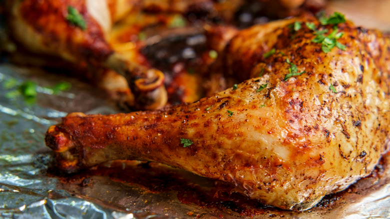 Broiled chicken leg garnished with herbs 