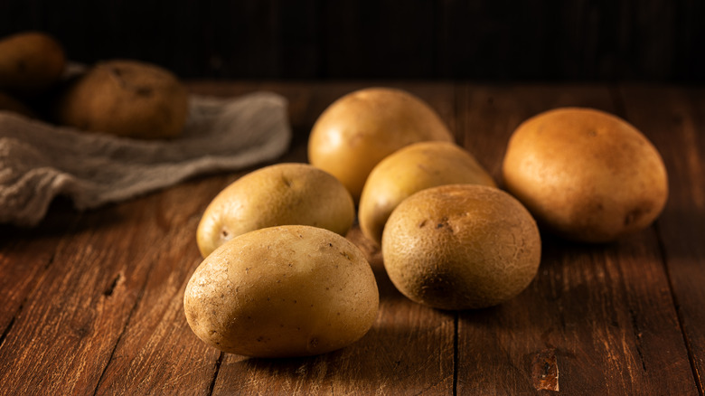 Raw potatoes on wooden table