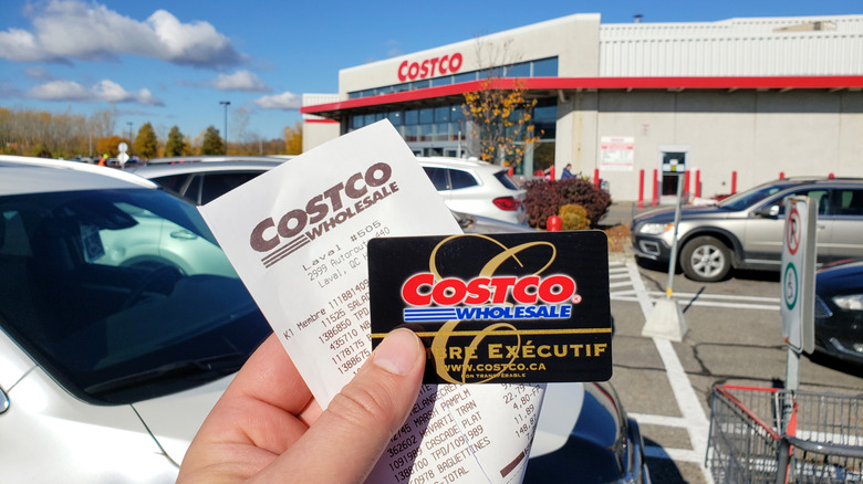 A person holding a Costco Executive card and receipt