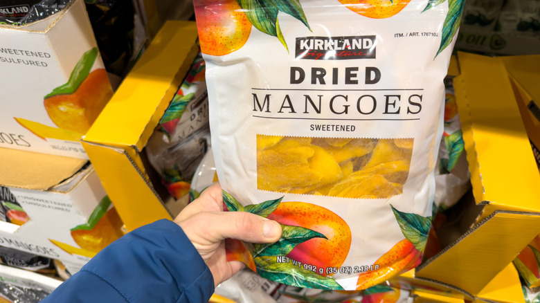hand holding bag of dried mangoes