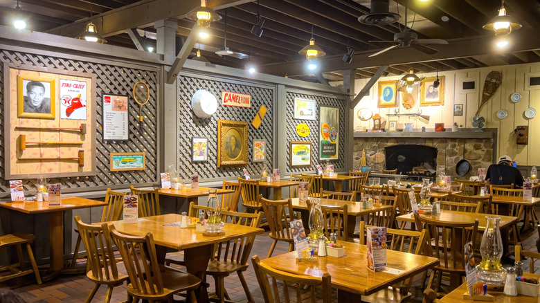 Inside of a Cracker Barrel with its trademark decor lining the walls and empty tables on the floor