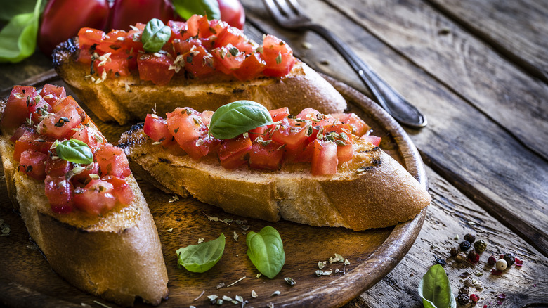 Three pieces of bruschetta on wooden plate on wooden table
