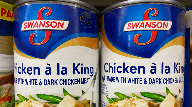 Two cans of Swanson Chicken à la King on store shelf.