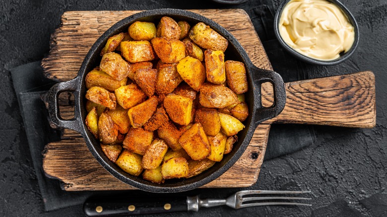 Patatas bravas in a skillet