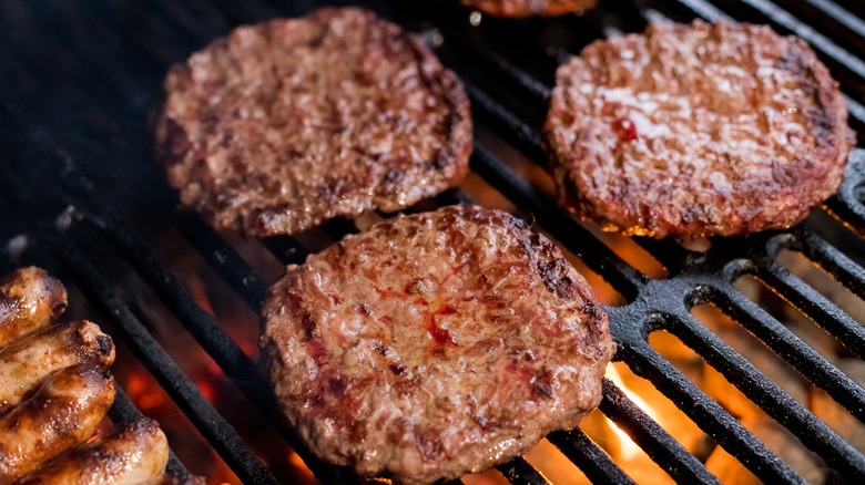 burger patties cooking on fire grill