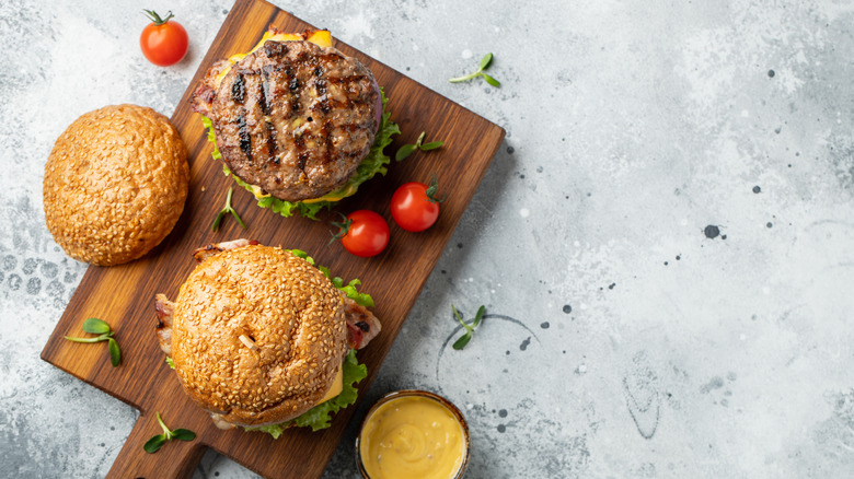homemade cheeseburgers assembled on cutting board