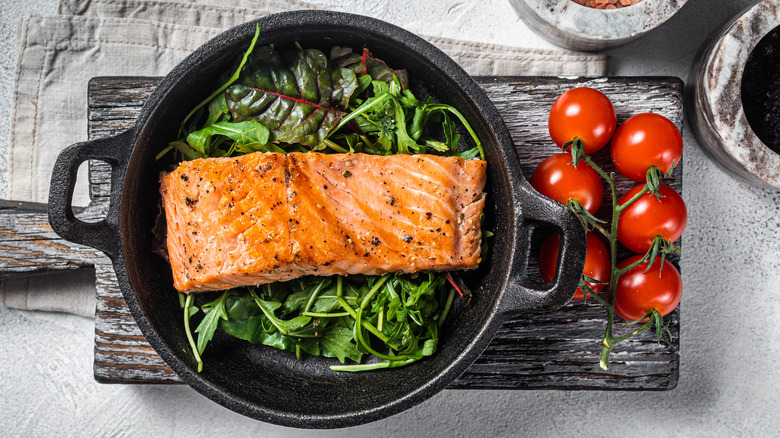 Salmon atop greens in skillet