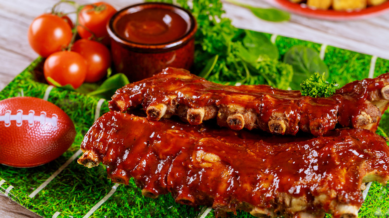 Barbecue ribs with barbecue sauce on a football field paper plate