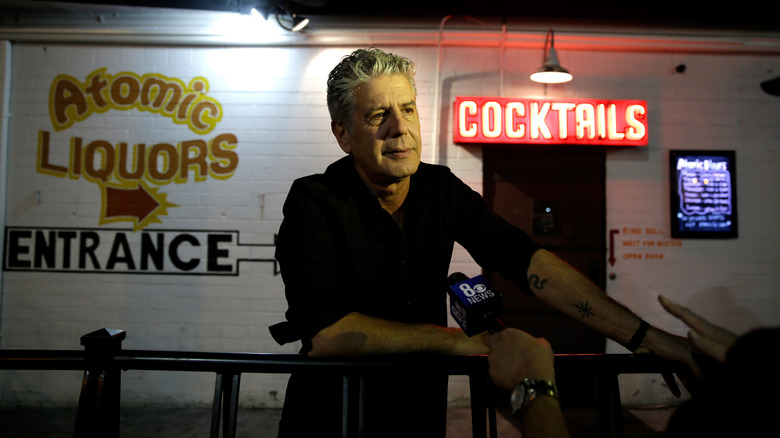 Bourdain in front of a bar