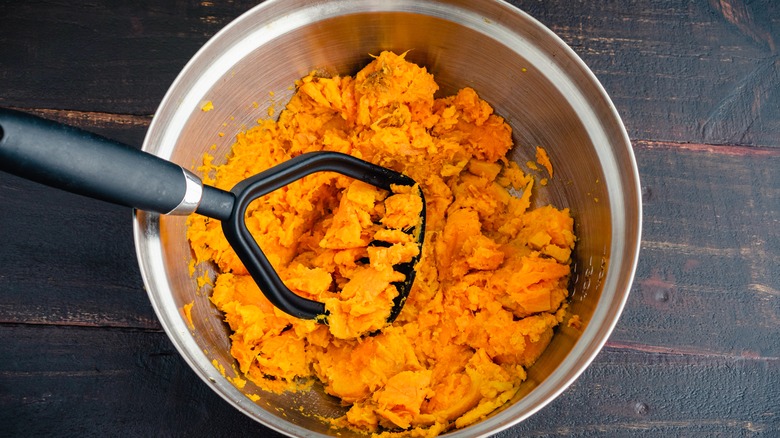 mashing sweet potato in bowl