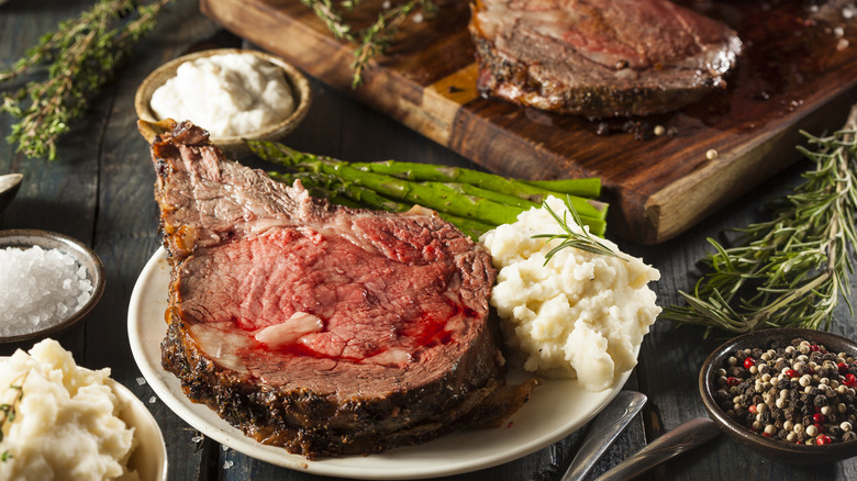 Prime rib on a plate with mashed potatoes and asparagus