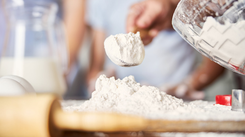 person scooping flour
