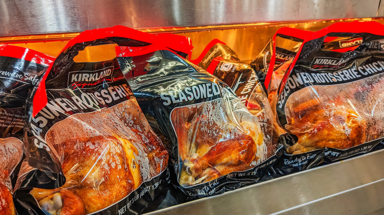 Kirkland rotisserie chicken bags sit under heat lamps.
