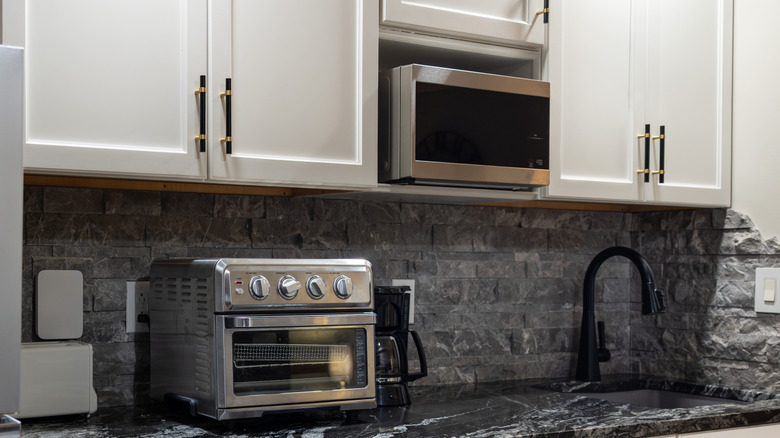 Countertop featuring microwave and toaster oven