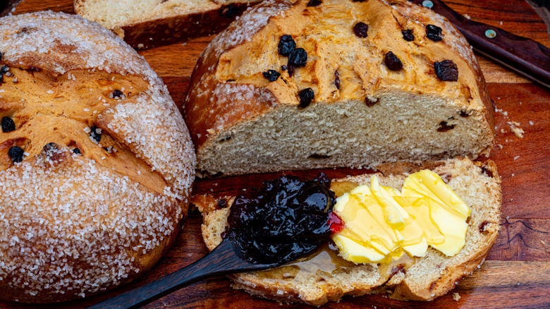 Irish soda bread with a lump of jam on a spoon and some Irish butter with honey on top