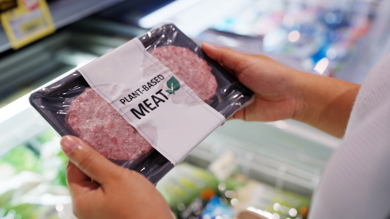 Shopper holding plant-based meat in grocery store