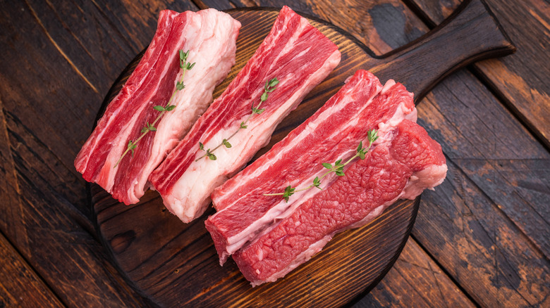 Raw beef short rib on a wooden backdrop
