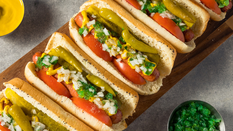 Chicago-style hot dogs loaded up with all the fixings on a board