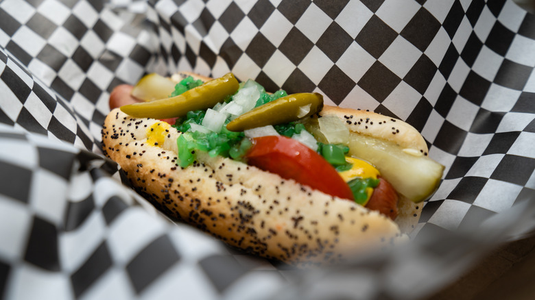 Chicago style hot dog on a checkered paper inside a serving tray