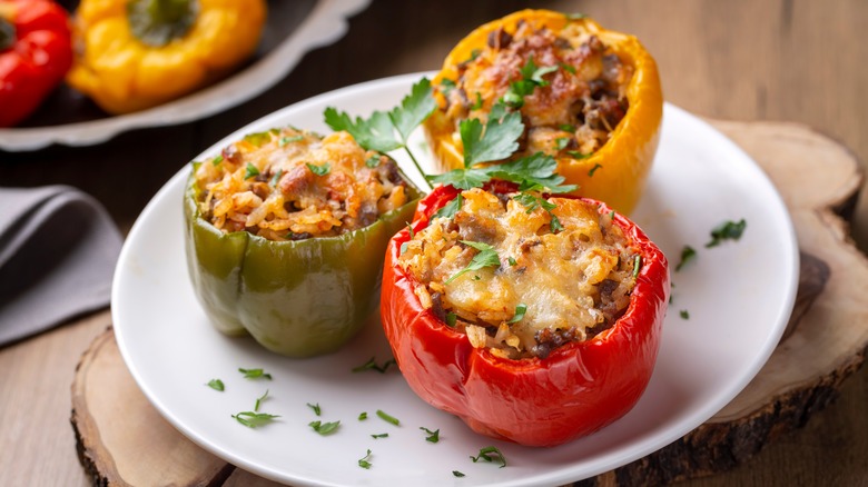 Green, yellow, and red stuffed peppers on a plate
