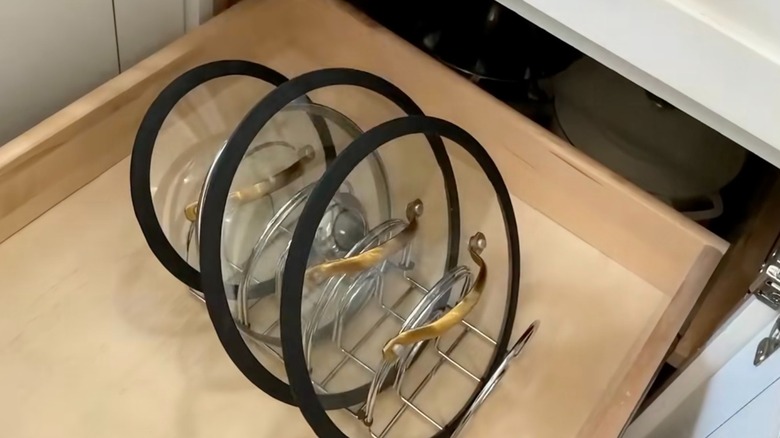 Pot lids organized inside Dollar Tree napkin holders