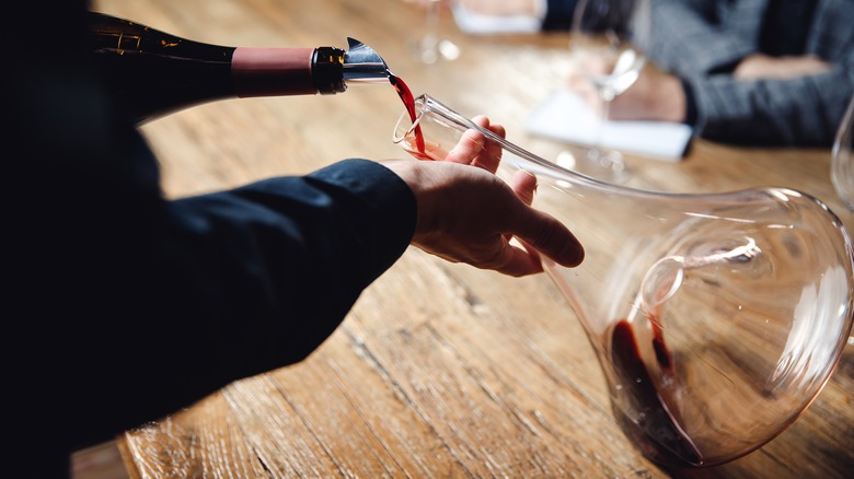 Person pouring wine into decanter