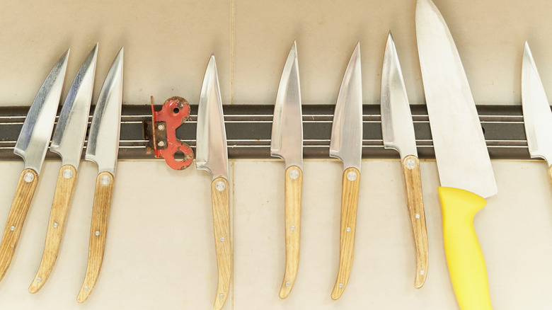 Kitchen knives on an exposed metal magnet strip