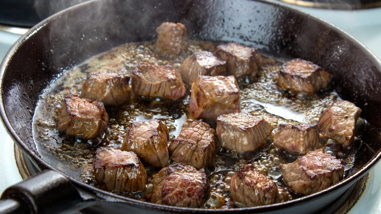Beef cubes searing in pan