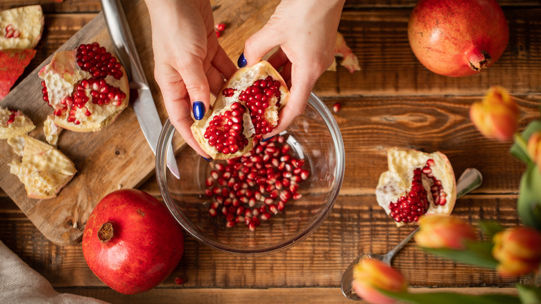 Removing pomegranate seeds in a bowl