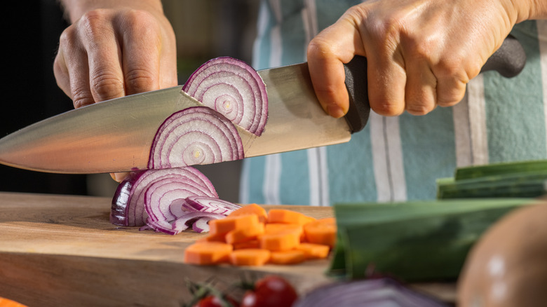 cook slicing an onion