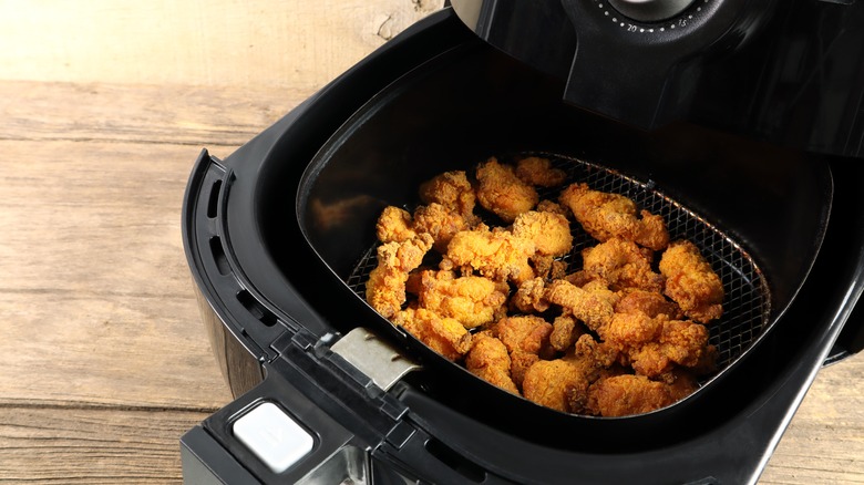 Small bites of fried chicken inside an air fryer