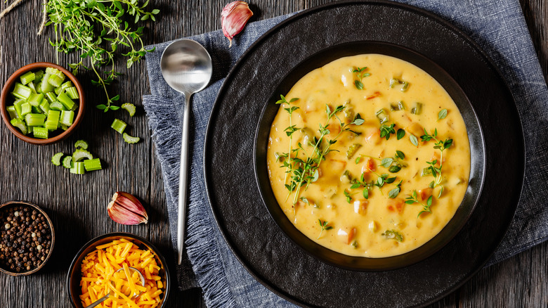 overhead shot of beer cheese soup on rustic background with ingredients