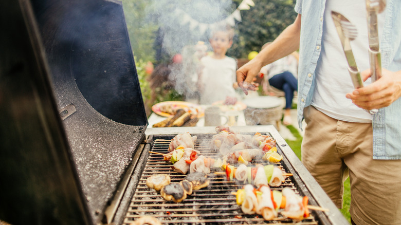 grill smoking with skewers on it