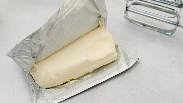 Unwrapped block of cream cheese on counter