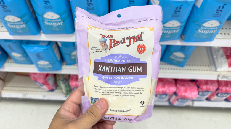 Hand holding bag of xanthan gum in grocery store