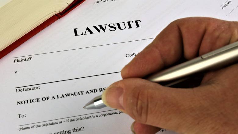 A man's hand holding a pen over some paperwork