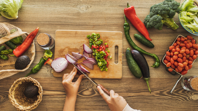 An overhead view of someone chopping vegetables