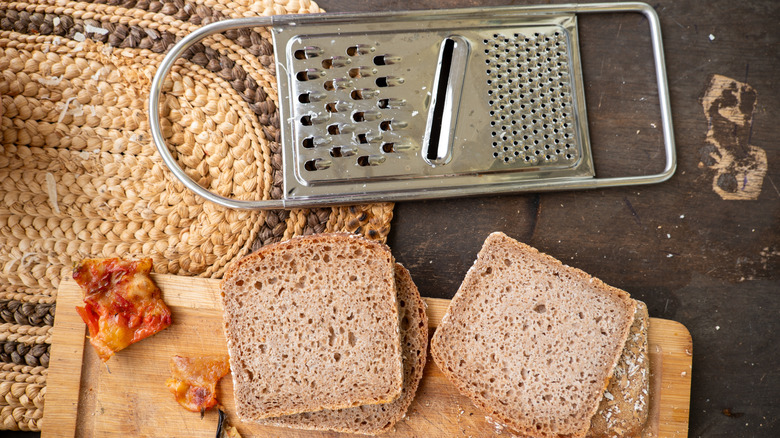 Flat grater laying next to four slices of bread