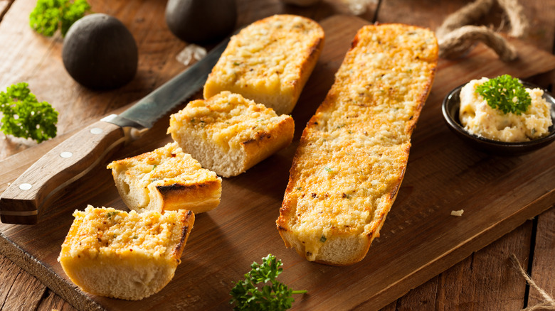 Cheesy garlic bread on a cutting board