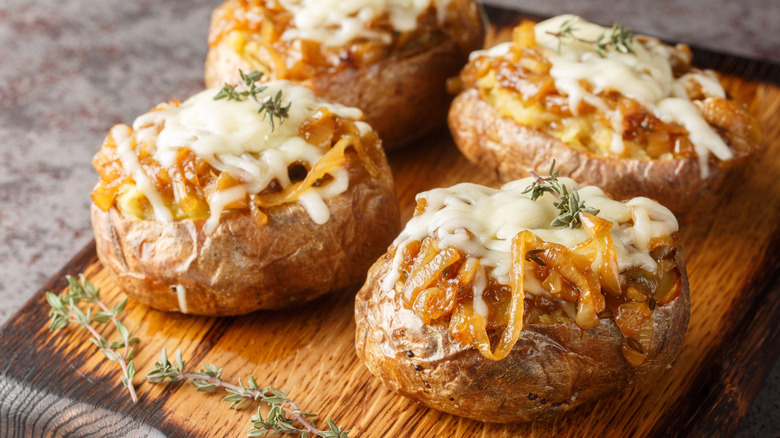French onion baked potatoes on a cutting board
