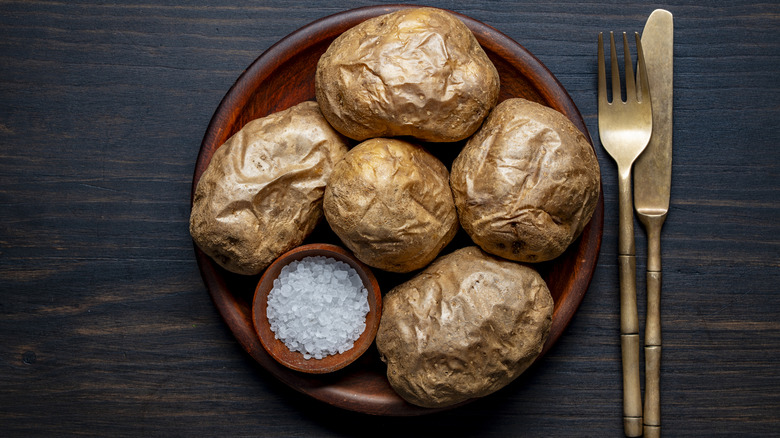Plate of baked potatoes and a bowl of coarse salt