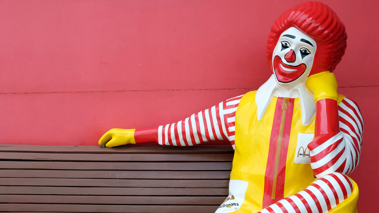 Ronald McDonald sitting on a bench 