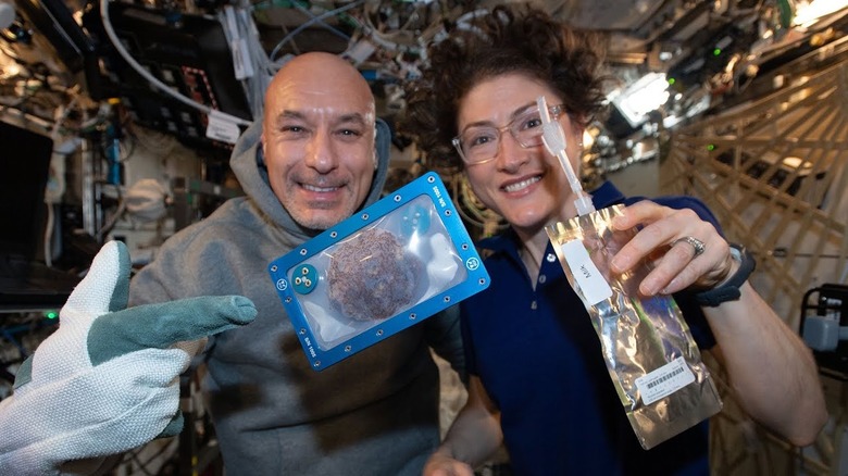 Astronauts Luca Parmitano and Christina Koch with the first cookie baked in space