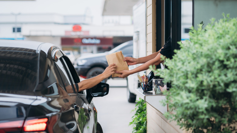 A person receiving bag at drive-thru window