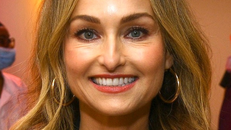Giada De Laurentiis smiling with long earrings and loose hair