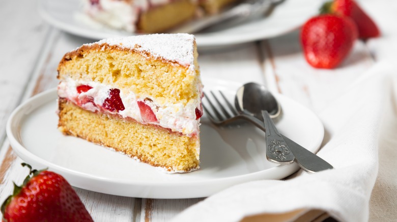 Slice of strawberry Victoria sponge cake on plate