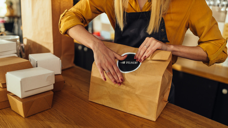 Someone prepping food for delivery